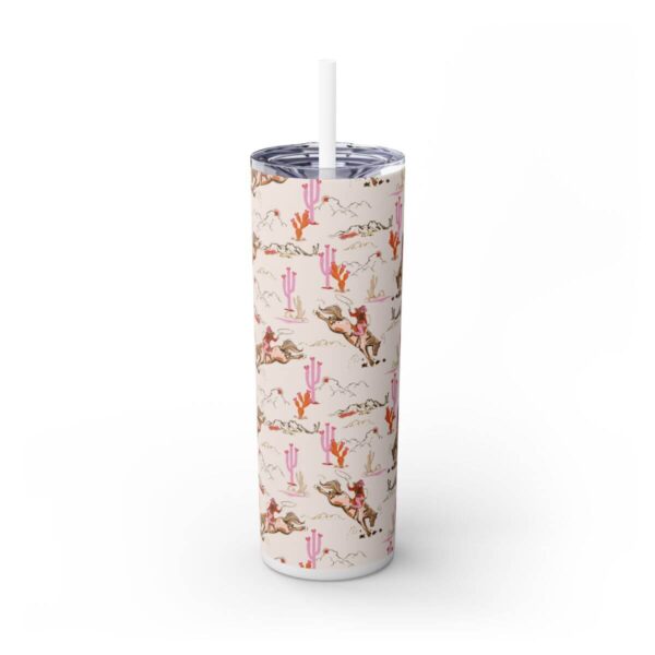 Front view of the Cowgirl Skinny Tumbler, showcasing a bold design with a bucking horse, pink cacti, and mountain illustrations in vibrant colors, with a clear lid and matching straw.